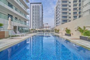 迪拜Stella Stays Fabulous Studio Dubai JVC Large Terrace的一座建筑物中央的游泳池