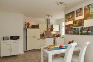 海利根达姆Residenz von Flotow Wohnung 01的厨房以及带桌椅的用餐室。