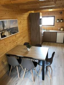 德兹维济诺Domki letniskowe Ibiza的一间带木桌和椅子的用餐室