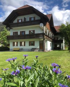 Kirchbach舒斯特尔旅馆的一座大房子前面有紫色的鲜花