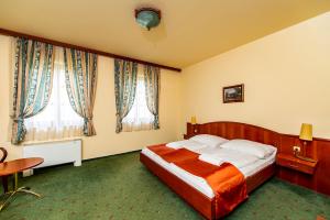 锡盖特圣米克洛什Gastland M0 Hotel & Conference Center的酒店客房设有一张床和两个窗户。