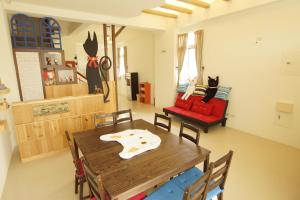 台东貓咪民宿Mini館-中午即可入房的一间带木桌和红色椅子的用餐室