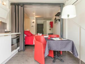 南特Gîte Nantes, 1 pièce, 2 personnes - FR-1-306-1182的一间厨房,里面配有桌子和红色椅子