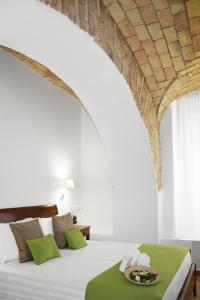 罗马罗马圆形大剧场度假公寓式酒店的一间卧室配有一张大床和一张绿桌