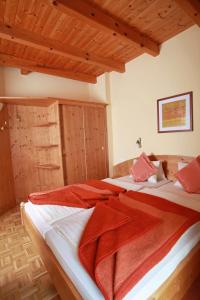 Kirchbach舒斯特尔旅馆的一间卧室配有两张带红色毯子的床。