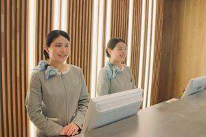 松本松本里士满酒店的站在镜子前的桌子上的女人