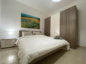 比尔泽布贾Rock Bay的卧室配有白色的床和墙上的绘画作品