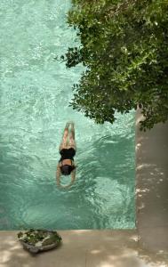 阿尔勒帕提库列酒店的漂浮在游泳池中的一个人