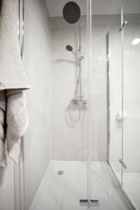 皮拉Niron Apartament Dom z Papieru Sztokholm的浴室里设有玻璃门淋浴