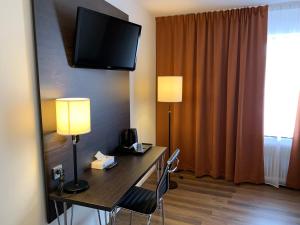Norsborg斯拉格斯塔沃尔多斯汽车旅馆的酒店客房设有一张桌子,墙上配有电视