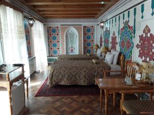 布哈拉Sasha & Son Hotel的卧室配有一张床铺,位于拥有色彩缤纷的墙壁的房间