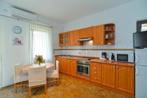 波雷奇Apartments Porec 336的厨房配有木制橱柜和桌椅