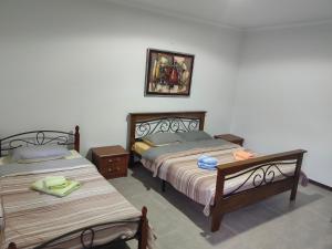 Kaji-SayArt Hotel Al Hayat的卧室配有两张床,墙上挂着一幅画