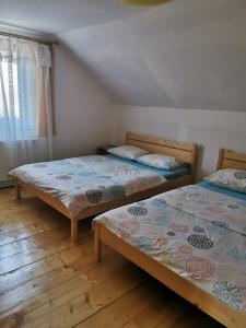 MoldoveneştiThe Wooden House的带窗户的客房内设有两张单人床。