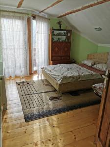MoldoveneştiThe Wooden House的一间卧室配有一张床,铺有木地板