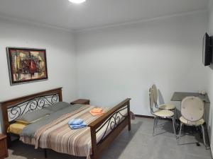 Kaji-SayArt Hotel Al Hayat的卧室配有一张床、一张桌子和椅子