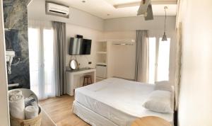 斯卡拉Anagennisi Hotel的卧室配有白色的床和电视