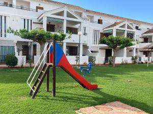 德尼亚Chalet adosado en urbanización con precioso jardín的一个带滑梯的庭院内的游乐场