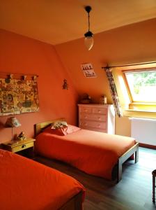 莫尔莱Maison dans un environnement boisé très calme的一间卧室拥有橙色的墙壁、一张床和窗户