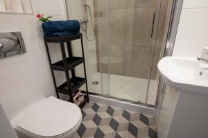 华沙Apartament Iga的带淋浴、卫生间和盥洗盆的浴室