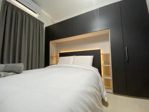 比尔泽布贾Hepburn Holiday Apartment的卧室配有白色的床和黑色橱柜。
