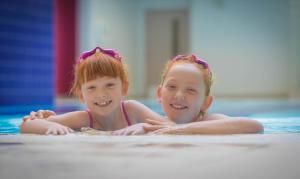 科克科克城克莱顿酒店的两个小女孩躺在游泳池里