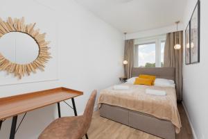华沙Metro Marymont Apartment by Renters的一间卧室配有一张床、一张书桌和一面镜子