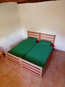 Brontallo农业斯恩豪拉酒店的一张带绿色床单的木床