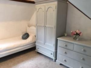 特灵Beautiful 1 bed cottage in countryside的一间白色卧室,配有一张床和一个梳妆台