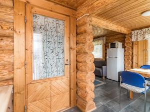 KokkosenlahtiHoliday Home Aurinkotupa by Interhome的木门,带桌子和冰箱的房间