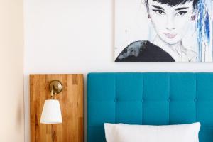 滨湖默尔比施Pension Laubenhof的床上方的画作,带有蓝色床头板