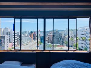 高知高砂酒店 的卧室设有大窗户,享有城市美景