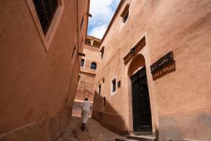 瓦尔扎扎特达尔卡玛旅馆的走在两座建筑之间的小巷的男人