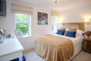 艾恩布里奇The Water Rat Ironbridge的白色卧室配有一张带蓝色枕头的大床