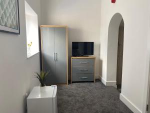 韦克菲尔德2D SPV Double En-suite Room的配有电视和带电视的梳妆台的房间