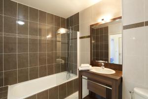 卡布勒通纳美尔勒斯塔萨德公寓式酒店的浴室配有盥洗盆和浴缸。
