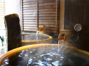 金泽Onyado Nono Kanazawa的客房内的热水浴池和喷泉