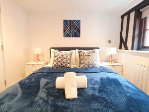 彼索普斯托福Stansted Airport Luxury Apartment Bishops Stortford Millars One Loft 4的一间卧室配有蓝色的床和2条毛巾
