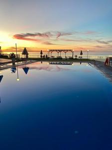 斯泰洛米诺斯诺蒂卡公寓酒店的一座享有日落美景的大型游泳池