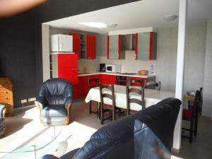 达默Hof ter Langeleye Planke的厨房配有红色橱柜和桌椅