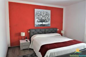 阿科Apartment Cuore di Arco的卧室设有红色的墙壁和一张床