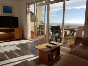 卡沃内拉斯Apartamento Vistas Espectaculares al Mar的带沙发、电视和桌子的客厅