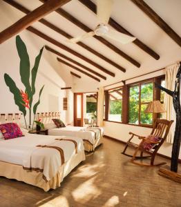 弗洛勒斯玛雅别墅酒店的带三张床的客房和窗户的天花板
