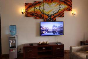 纳纽基Glamour Suites的客厅设有壁挂式平面电视。