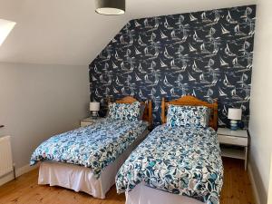 瓦特维尔Holiday Home Waterville的一间卧室设有两张床,墙上有鸟