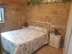 庞特维德拉A Casiña do Xastre的一间卧室设有一张床和石墙