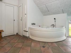 菲耶勒鲁普海滨12 person holiday home in Glesborg的浴室设有大型白色浴缸,铺有瓷砖地板。