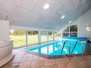 菲耶勒鲁普海滨12 person holiday home in Glesborg的一个带卫生间的别墅内的游泳池