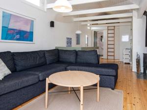 菲耶勒鲁普海滨12 person holiday home in Glesborg的客厅配有蓝色的沙发和桌子