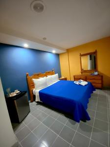 加拉加斯Hotel Renovación的一间卧室配有蓝色的床和镜子